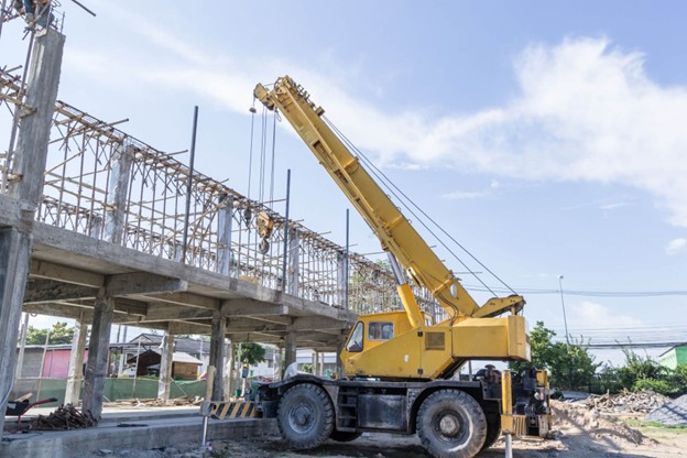 Crane boom picking heavy load on bridge